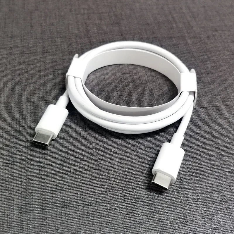 Coiled white USB-C to USB-C cable on a gray fabric surface, secured with a strap.