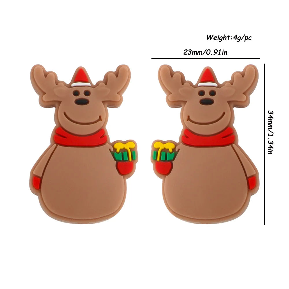 Two cartoon reindeer figures with antlers, wearing red scarves and hats, holding yellow and green gifts. Dimensions shown: 34mm by 23mm, weight 4g each.