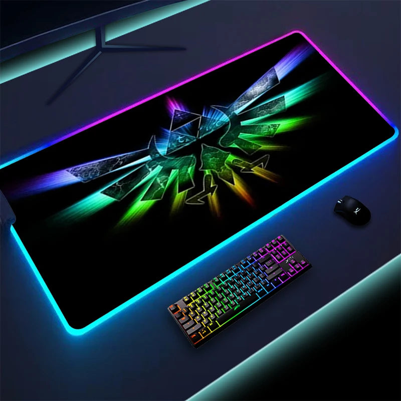 A gaming setup with a large RGB mousepad featuring a colorful symbol, next to a rainbow-lit keyboard and a black mouse, all on a dark desk with ambient lighting.