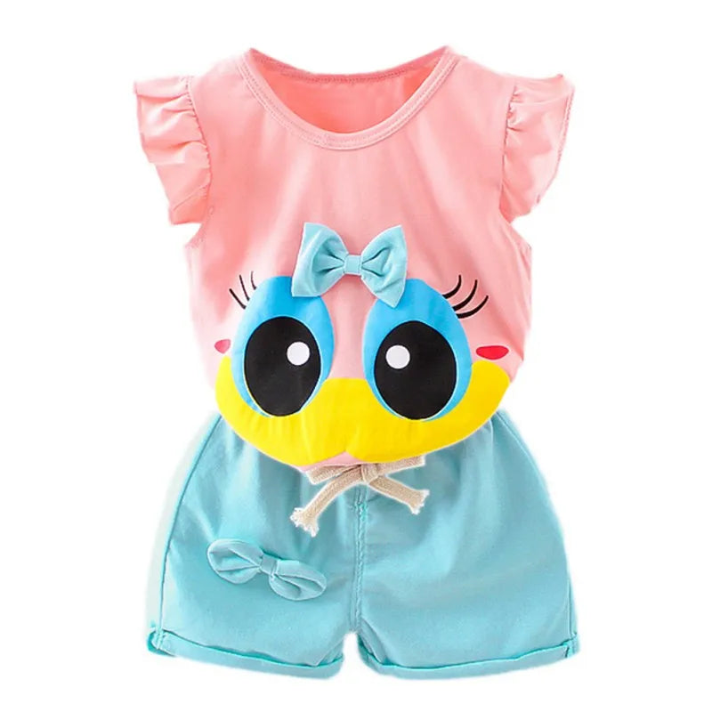 Pink and blue children's romper with ruffled sleeves and a cartoon face print, featuring large eyes and a bow. The bottom has a matching fabric bow accent.