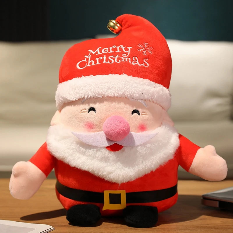 A plush Santa Claus toy with rosy cheeks, a white beard, and a red hat with "Merry Christmas" embroidered on it, sitting on a wooden surface.