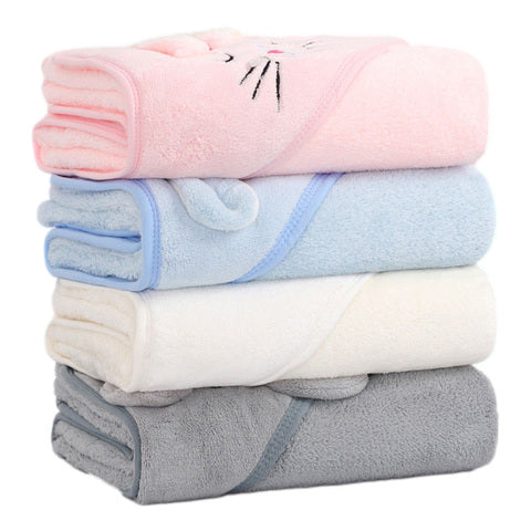 A stack of four soft, folded towels in pastel colors: pink with a cat face design, light blue, white, and gray, each with a coordinating trim, neatly arranged.
