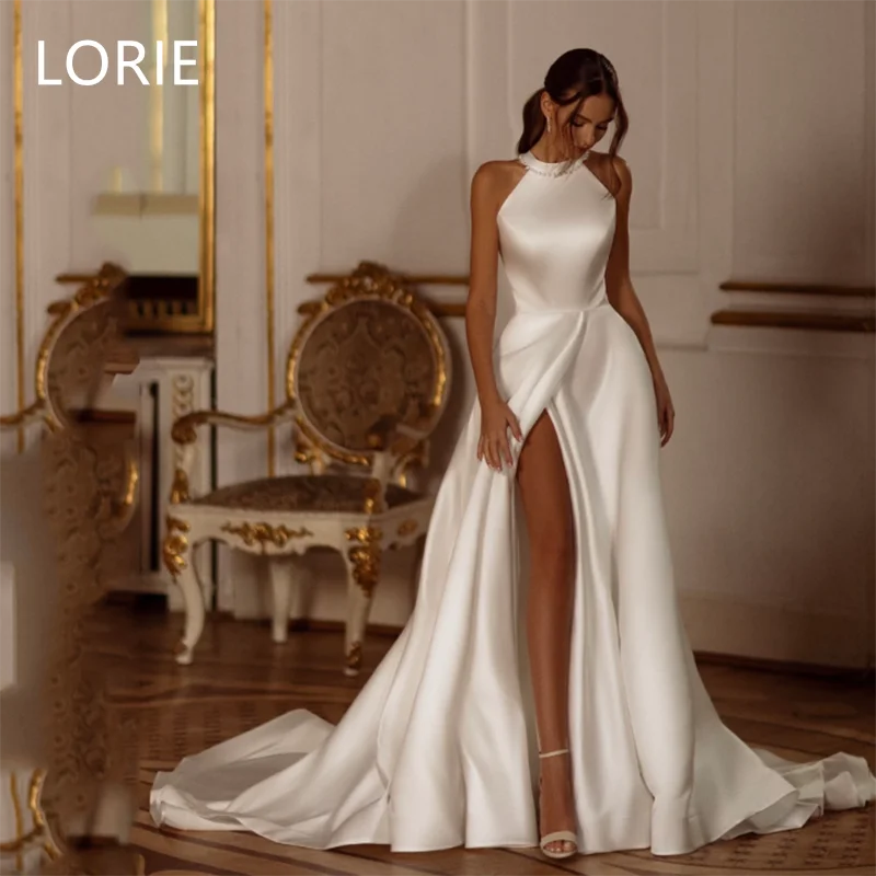 Elegant woman in a luxurious white gown with a high slit stands in an opulent room with ornate furniture. Her hair is styled in loose waves.