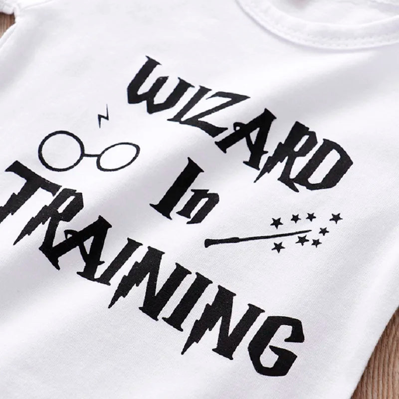 White shirt with "Wizard In Training" in black, featuring glasses with a lightning bolt and a wand with stars.
