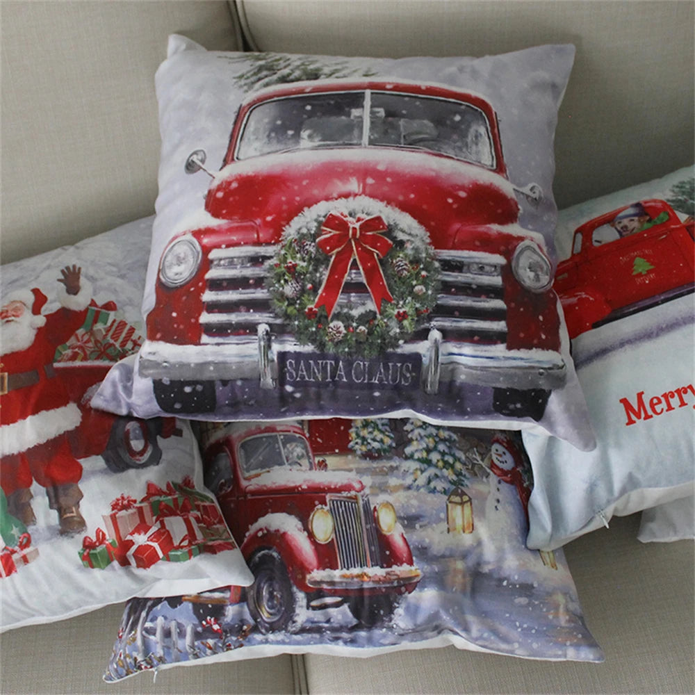 Festive pillows featuring a red vintage truck with a wreath, Santa Claus, gifts, and Christmas scenes. Snowflakes add a wintery touch, enhancing the holiday spirit.