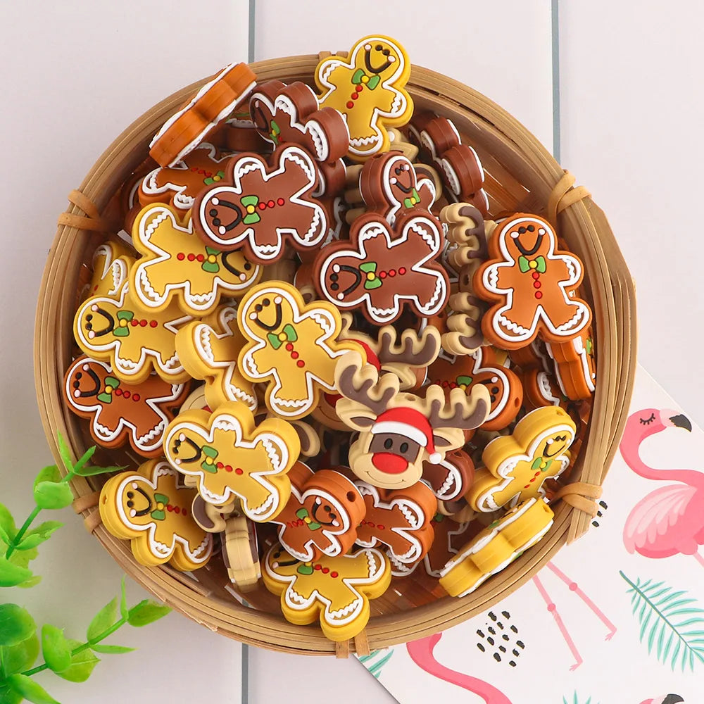 A wooden basket with colorful gingerbread man clips in brown and yellow, decorated with green bows and red buttons. A reindeer clip wearing a Santa hat is also visible.