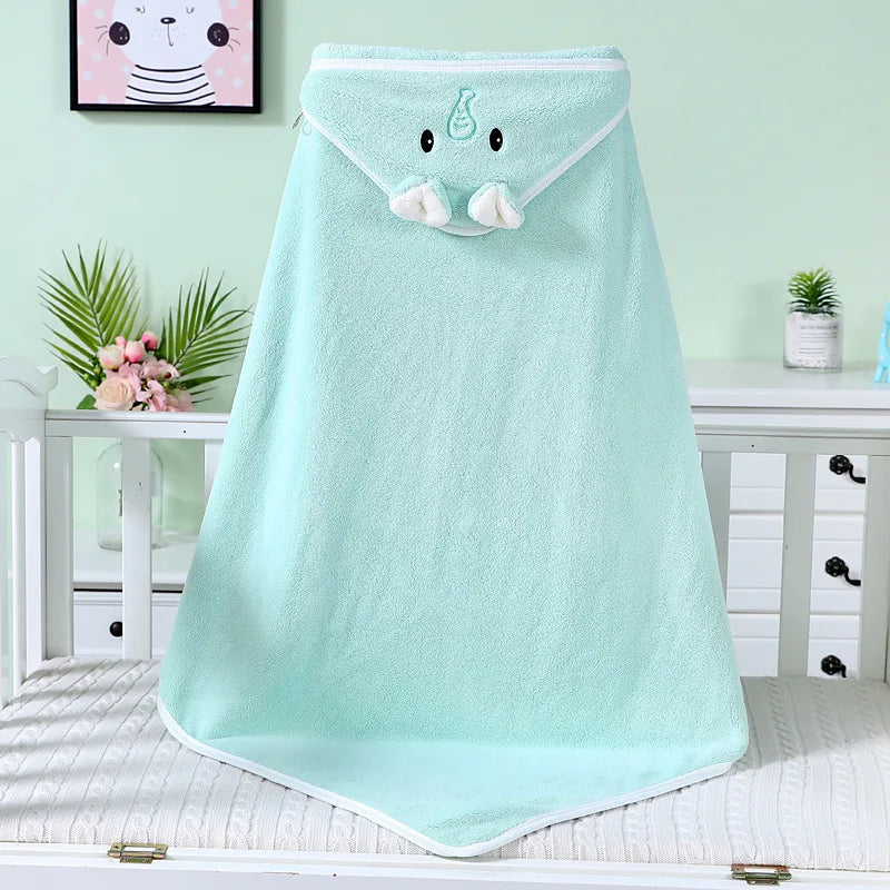 Light blue elephant-themed baby towel draped over a crib. The towel features a cute face and trunk, with a nursery decorated in soft pastel colors in the background.