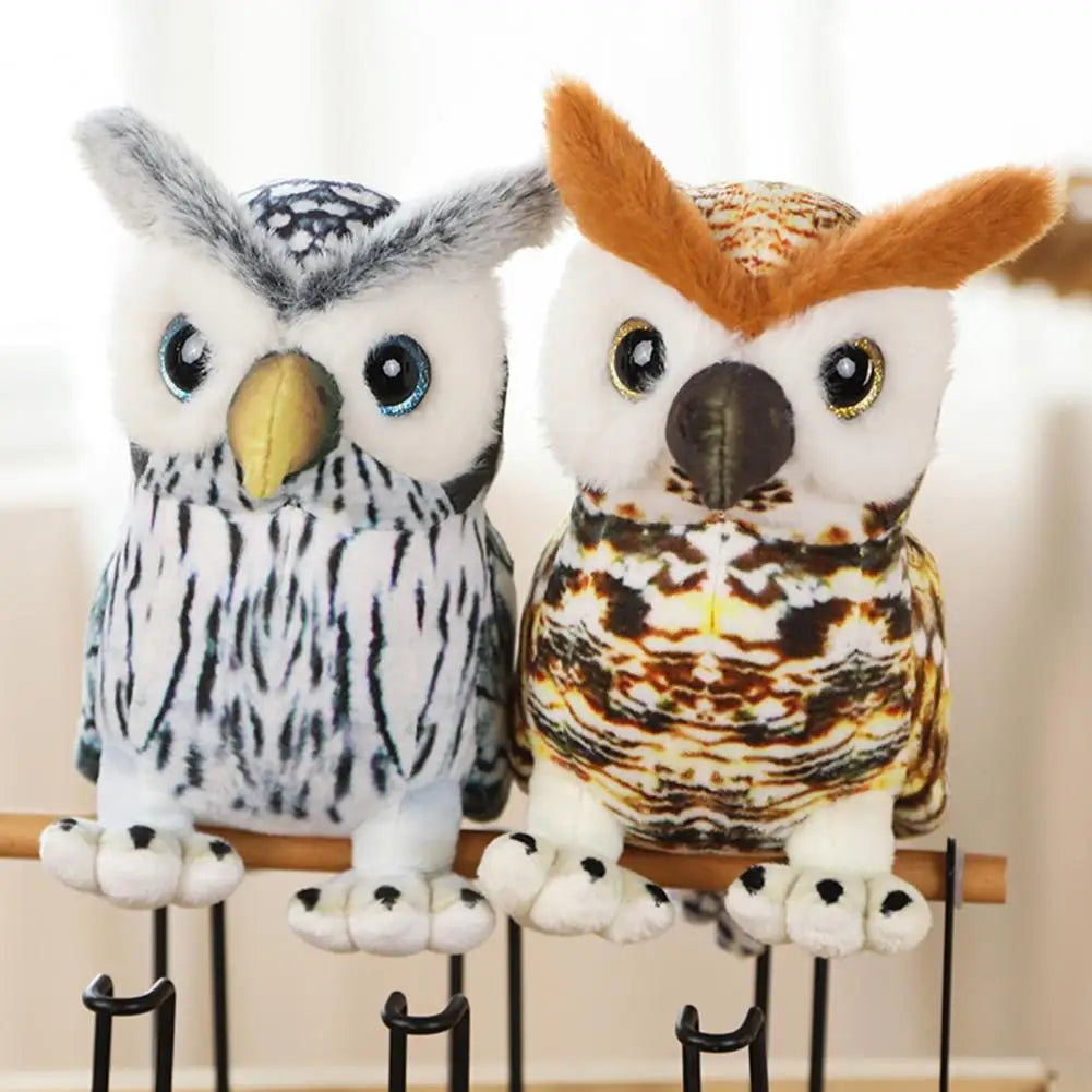 Two plush owl toys perched on a rod, one gray with black patterns and the other brown with orange markings. Both have large, expressive eyes and fluffy accents.