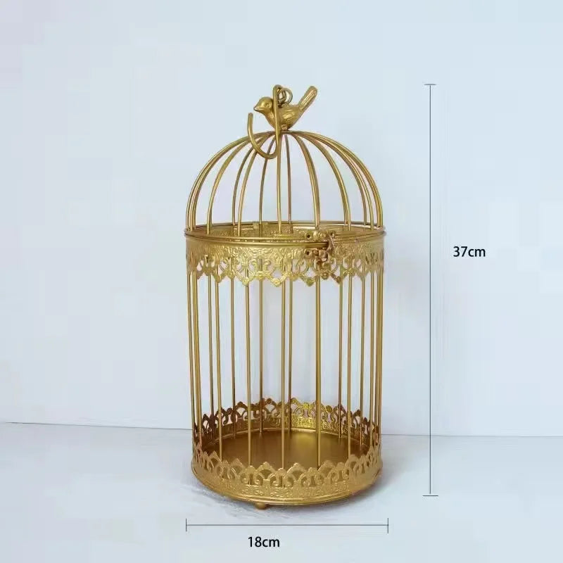 Gold decorative birdcage with intricate designs, 37cm tall and 18cm wide. The top features a bird ornament, set against a plain white background.