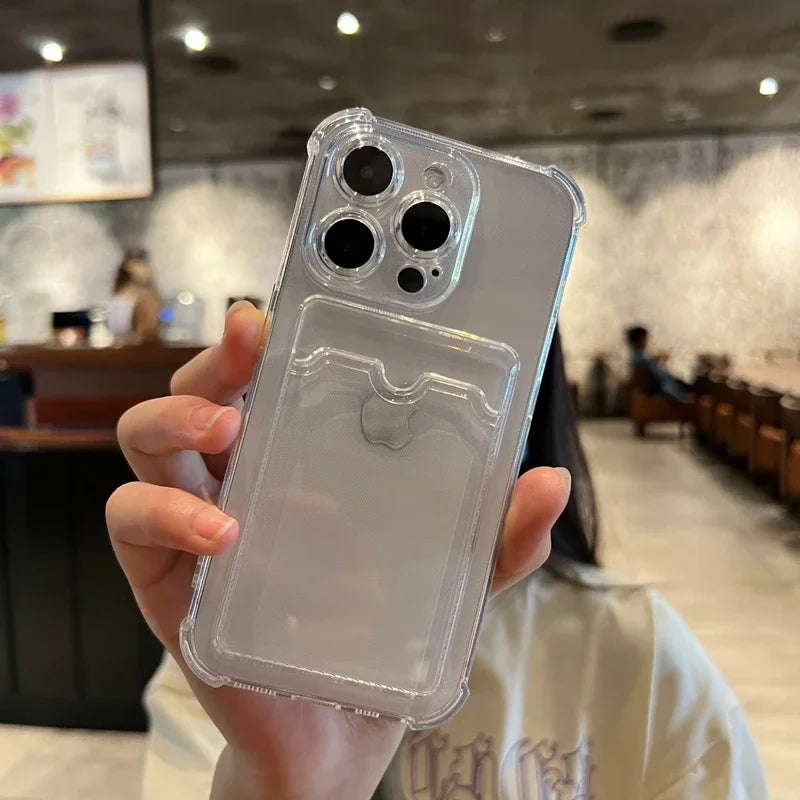 A clear phone case with a card slot on an iPhone held in a hand, against a blurred cafe background.