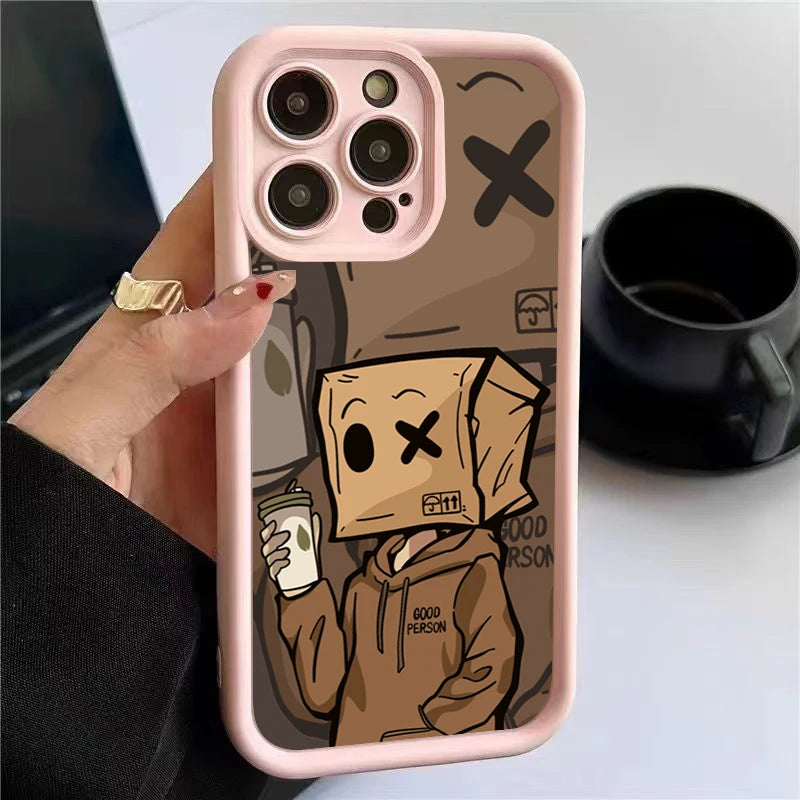 A hand holds a phone with a pink case featuring a cartoon character wearing a paper bag with an "X" eye, holding a drink. Background shows a black cup.