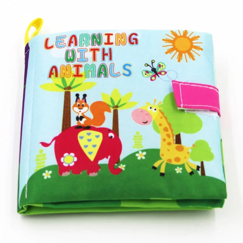 Colorful children's cloth book titled "Learning with Animals," featuring illustrations of a squirrel on an elephant, a giraffe, trees, sun, and a butterfly.