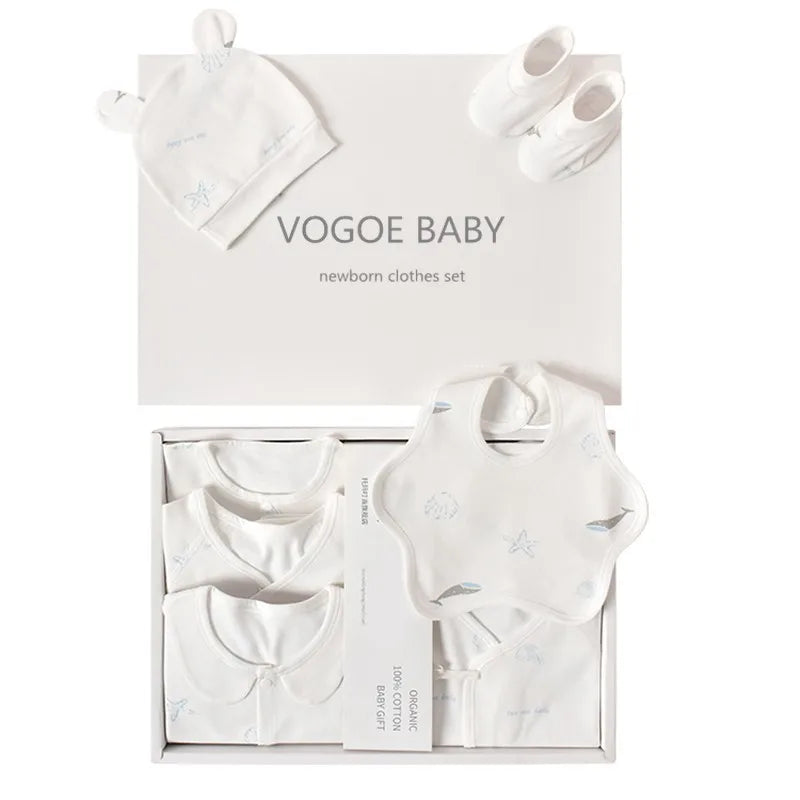 Vogoe Baby newborn clothes set includes a hat with ears, small shoes, and onesies. Items are white with subtle blue patterns, neatly arranged in a stylish gift box.