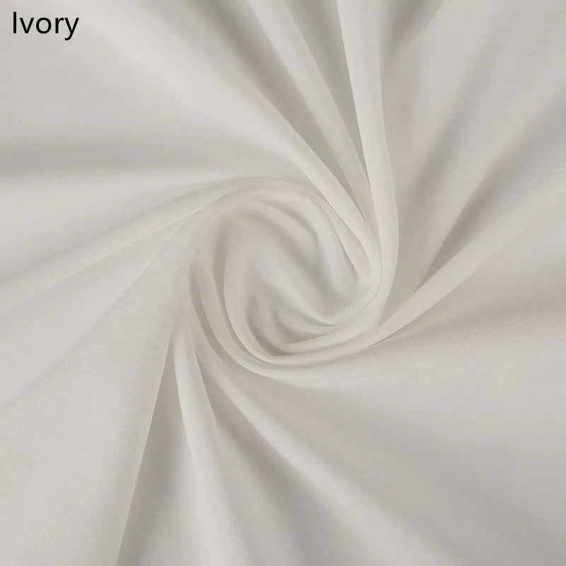 Ivory fabric draped in a soft spiral pattern, showcasing its smooth texture and gentle folds. Labels the color as ivory in the top left corner.