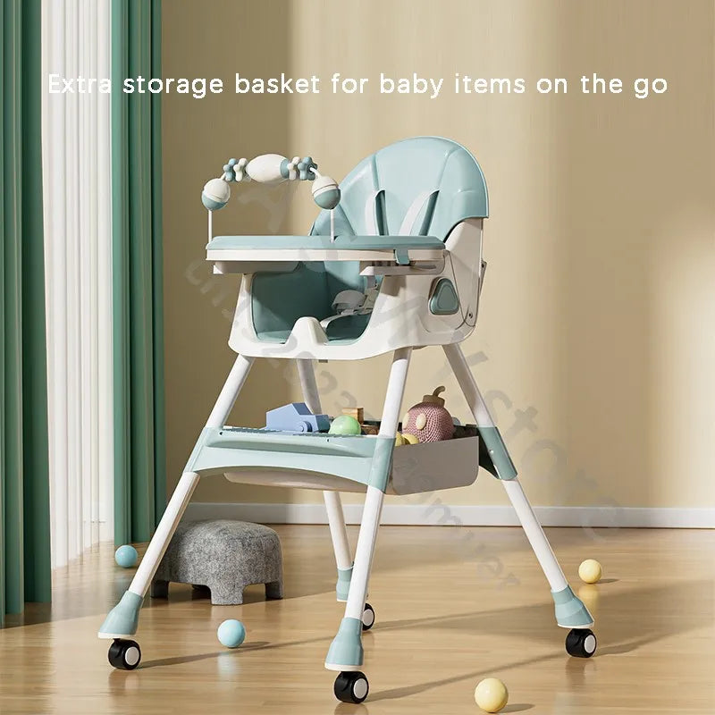 A mint green baby high chair with removable tray, toys hanging on the bar, and wheels. An extra storage basket under the seat holds baby items. Curved lines and wood floor visible.