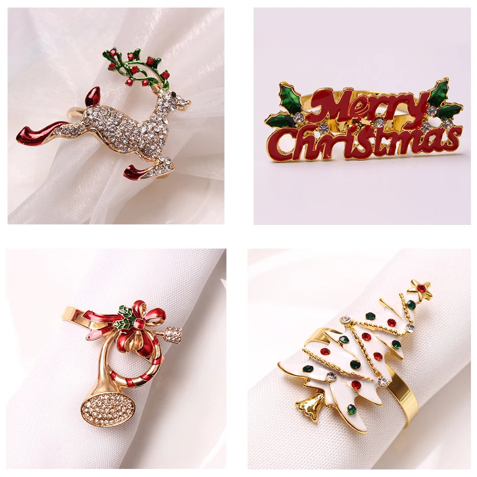 Festive napkin rings: a rhinestone reindeer, "Merry Christmas" sign, bell with red bow, and white Christmas tree with colorful gems, each on white napkins.