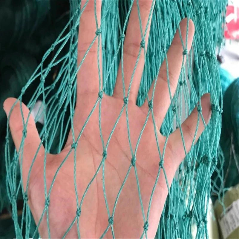 A hand behind a green net, with fingers visible through the mesh. The net's thin strands are knotted at intersections, forming diamond shapes, against a blurred background.
