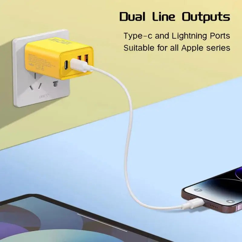 A yellow charger with dual Type-C and Lightning ports is plugged into a wall outlet. A white cable connects the charger to a smartphone on a table. Text: "Dual Line Outputs."