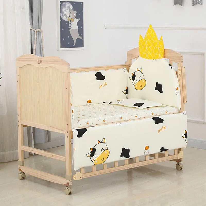 Wooden baby crib with cow-themed bedding, including cow print and "milk" text. A yellow crown pillow is attached at one end. A moon and animal wall art decorates the room.