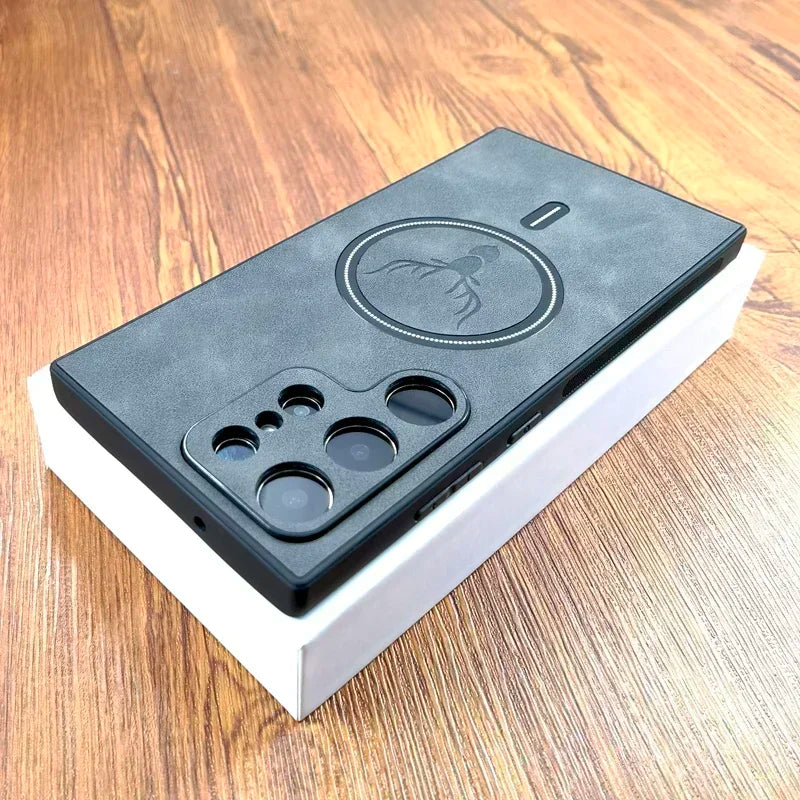 Black smartphone on a white box with a textured case featuring an octopus design. The phone has multiple camera lenses and is placed on a wooden surface.