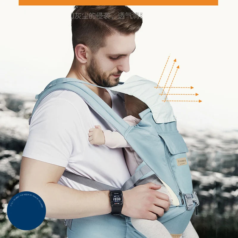 A man in a white shirt wears a blue baby carrier, holding a baby with a hood. The carrier features sun protection arrows, and the man wears a smartwatch displaying "10:31".