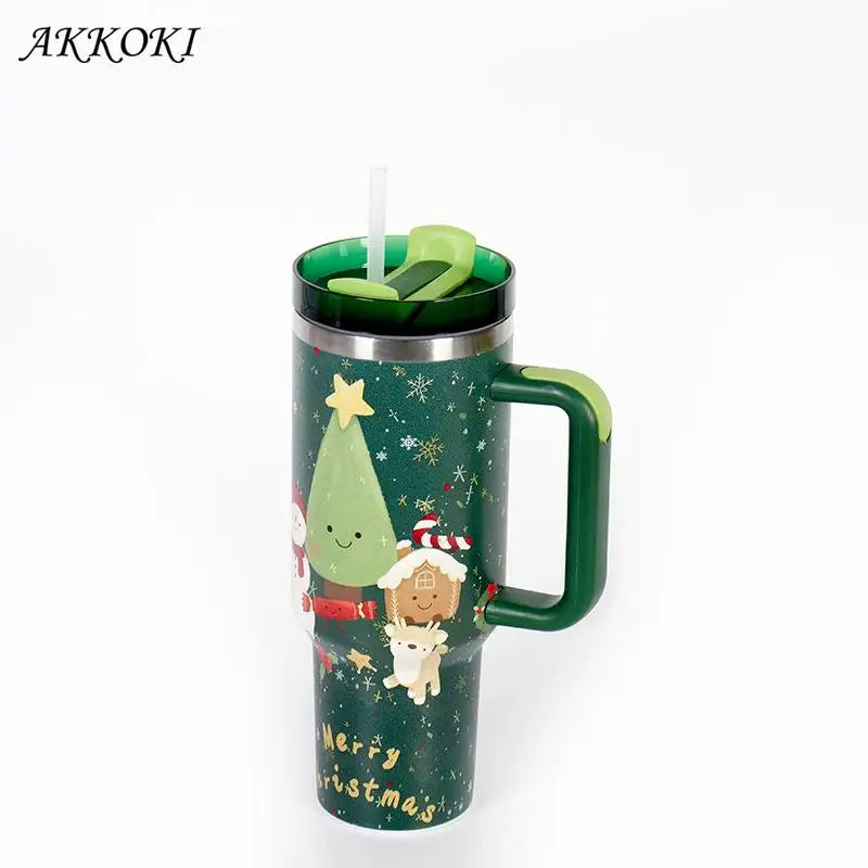 Festive travel mug with Christmas tree, reindeer, and Santa design; dark green handle; lid with straw; text "Merry Christmas" at bottom; brand name "AKKOKI" in top left.