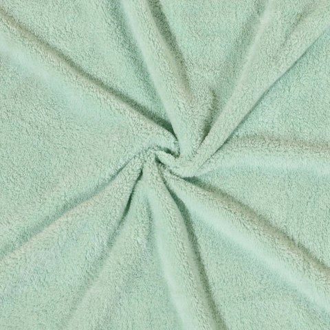 A soft, light green fabric twisted into a spiral pattern, showcasing its plush texture and subtle sheen. The material appears thick and cozy, suitable for towels or blankets.