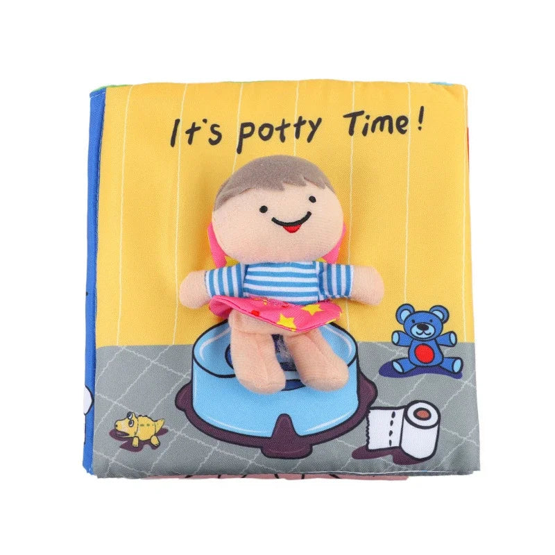 Soft cloth book cover with "It's potty Time!" text. Features a fabric doll sitting on a potty, surrounded by a toy bear and toilet paper illustrations. Bright, colorful design.