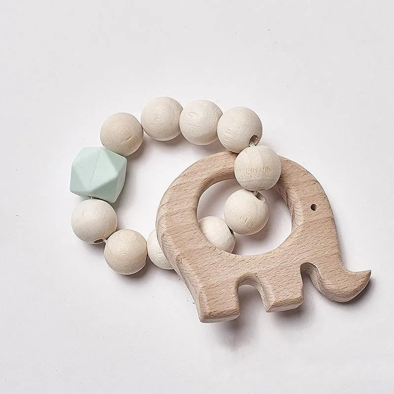 Wooden elephant teether attached to a string of cream-colored beads with a mint green geometric bead, set against a white background.