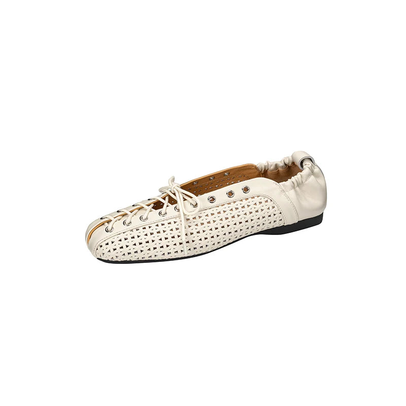 White leather shoe with lattice cutouts, metal eyelets, and laces. It features an elasticized heel and black sole, blending casual and stylish elements in its design.