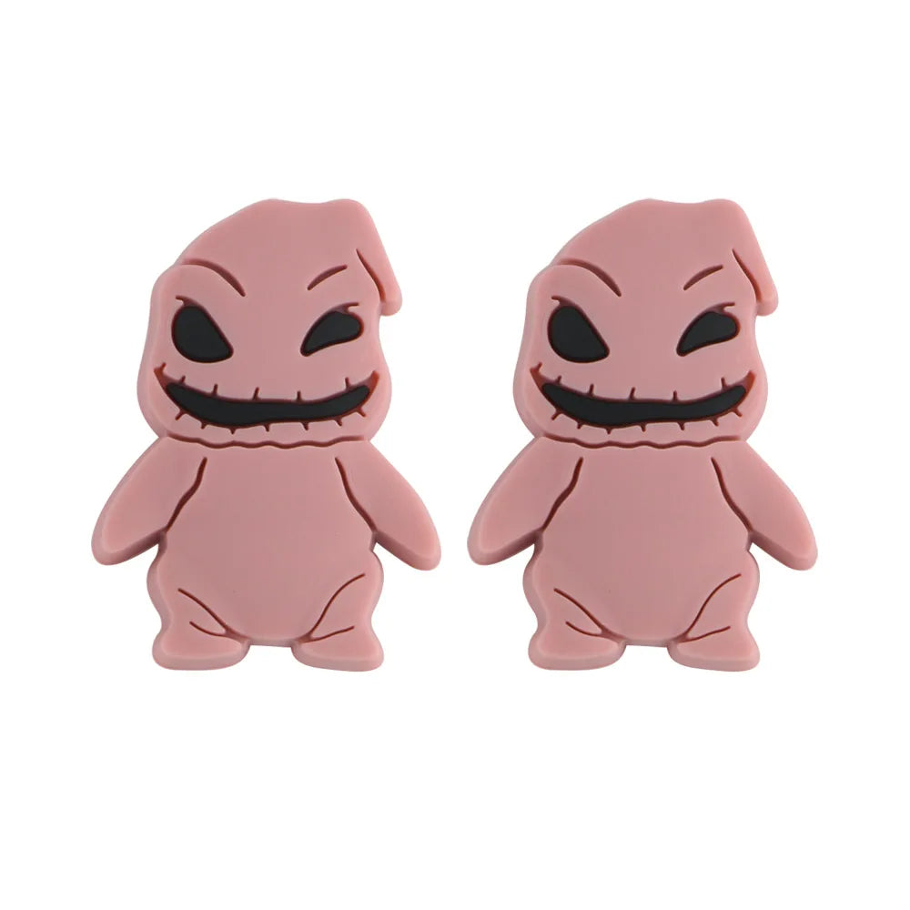 Two pink cartoonish figures with mischievous grins and black eyes, featuring stitched mouth details. They stand side by side, resembling playful, whimsical characters.