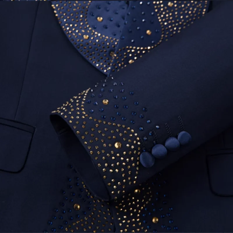 Navy blue suit with intricate gold and blue bead embellishments on the jacket and sleeve. Matching fabric buttons on the cuff add an elegant touch.