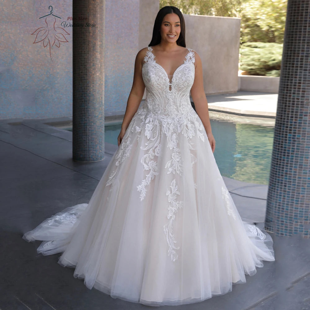 Bride in a flowing white wedding gown with intricate lace detailing and a plunging neckline, standing near a pool with tiled columns and greenery in the background.