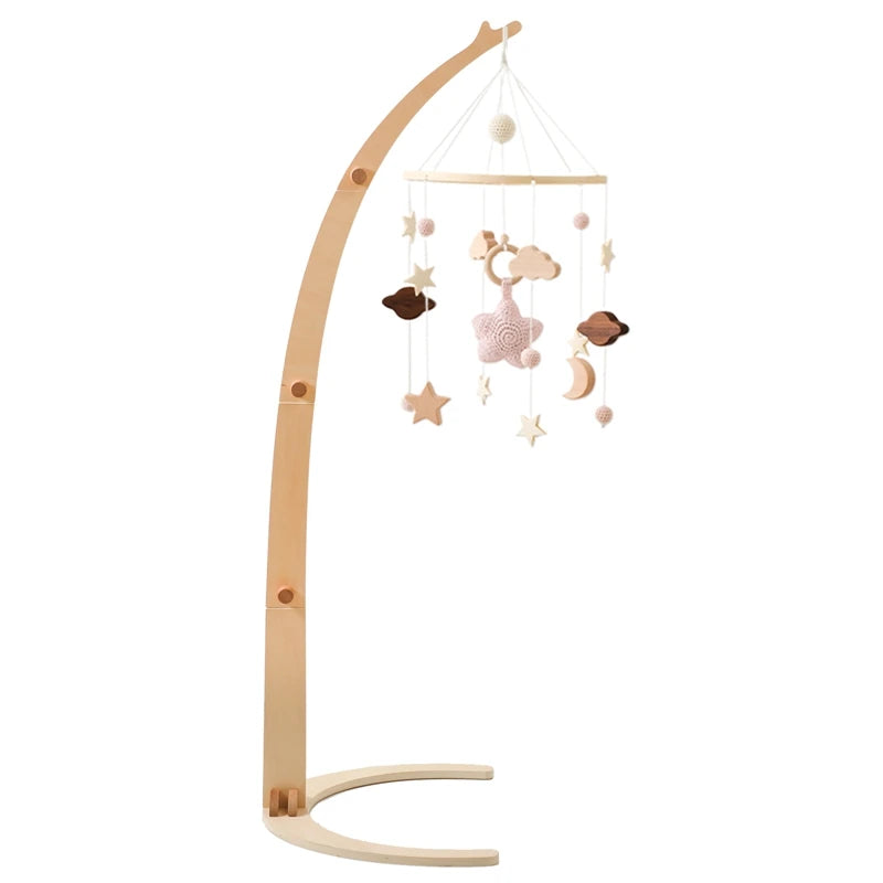 A wooden baby mobile stand with hanging soft toys, including stars, clouds, and crescent moons, in neutral pastel colors. The stand has an elegant, curved design.