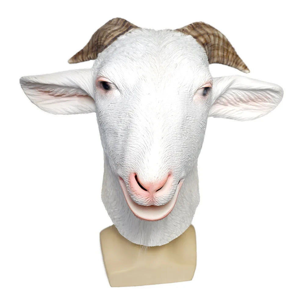 Realistic white goat mask with detailed textured fur and curved brown horns, featuring an open mouth, pink nostrils, and expressive eyes, displayed on a beige stand.