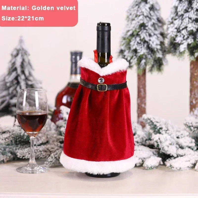 A wine bottle dressed in a red Santa cloak with a black belt, set on a table with a glass of wine and snowy trees in the background. Text reads: "Material: Golden velvet, Size: 22*21 cm."