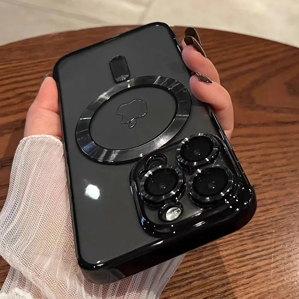 A hand holding a sleek black phone with an Apple logo and circular design on the back, featuring a triple-lens camera, set against a wooden table background.