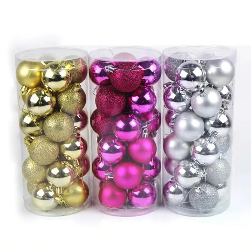 Three cylindrical containers holding Christmas ornaments in gold, pink, and silver colors. Each container has a mix of shiny and glittery baubles for holiday decoration.