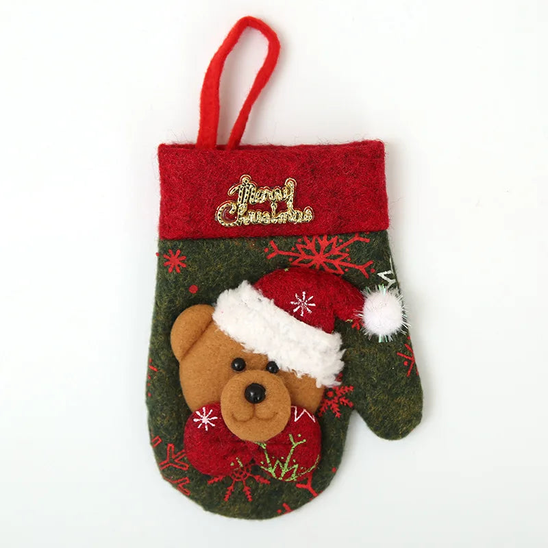 A festive Christmas mitten ornament with a teddy bear wearing a Santa hat, adorned with red snowflakes and gold "Merry Christmas" embroidery, hanging by a red loop.