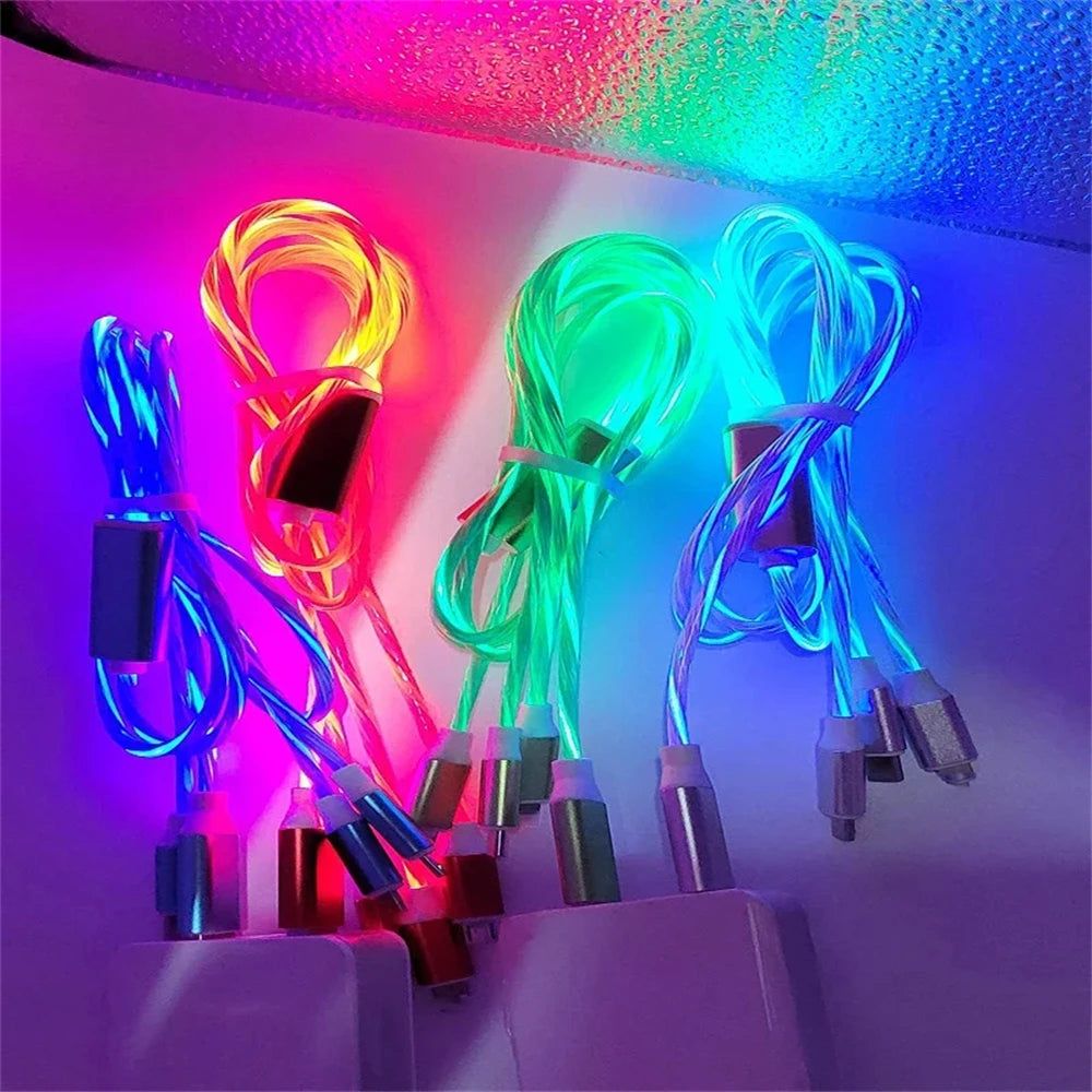 Four glowing USB cables in vibrant pink, green, blue, and yellow are displayed against a reflective surface, creating a colorful light display.