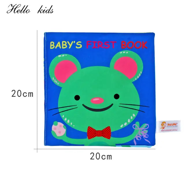 Blue baby book cover featuring a smiling green mouse with pink ears and a red bow tie, holding gifts. Text reads "BABY'S FIRST BOOK." Book dimensions are 20cm by 20cm.