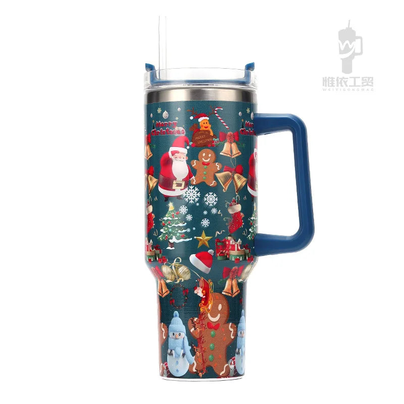 Festive travel cup with handle, featuring Christmas-themed designs: Santa, gingerbread men, snowflakes, bells, and gifts on a dark blue background with a clear lid and straw.