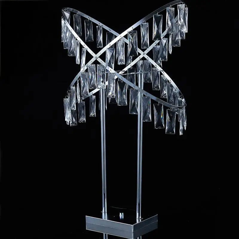 A modern crystal sculpture with intersecting metallic rings adorned with hanging rectangular prisms, set against a black background.