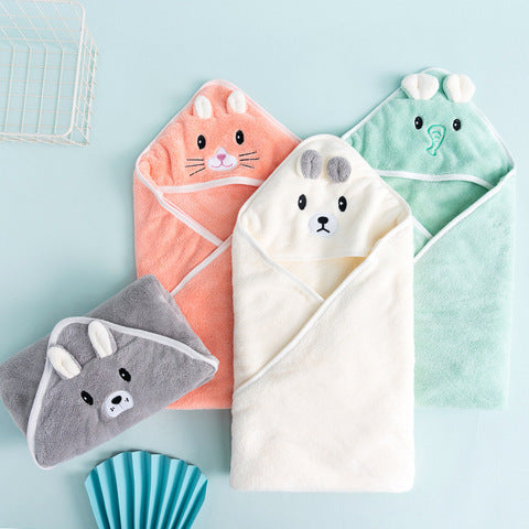 Three hooded baby towels shaped like animals and a matching gray washcloth are displayed on a pastel blue background, featuring designs of a bunny, bear, elephant, and donkey.