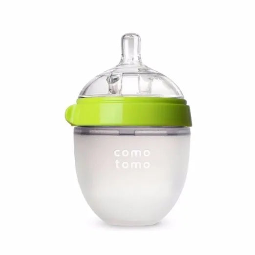 Clear silicone baby bottle with a green lid, soft silicone body, and a nipple top. The design is ergonomic, resembling a breast for easy transition between nursing and bottle-feeding.