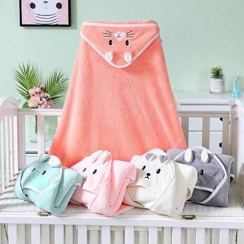 Five colorful animal-themed hooded towels, in mint, pink, cream, and gray, are arranged on a cot. The orange towel hangs upright, displaying a cute animal face with ears.