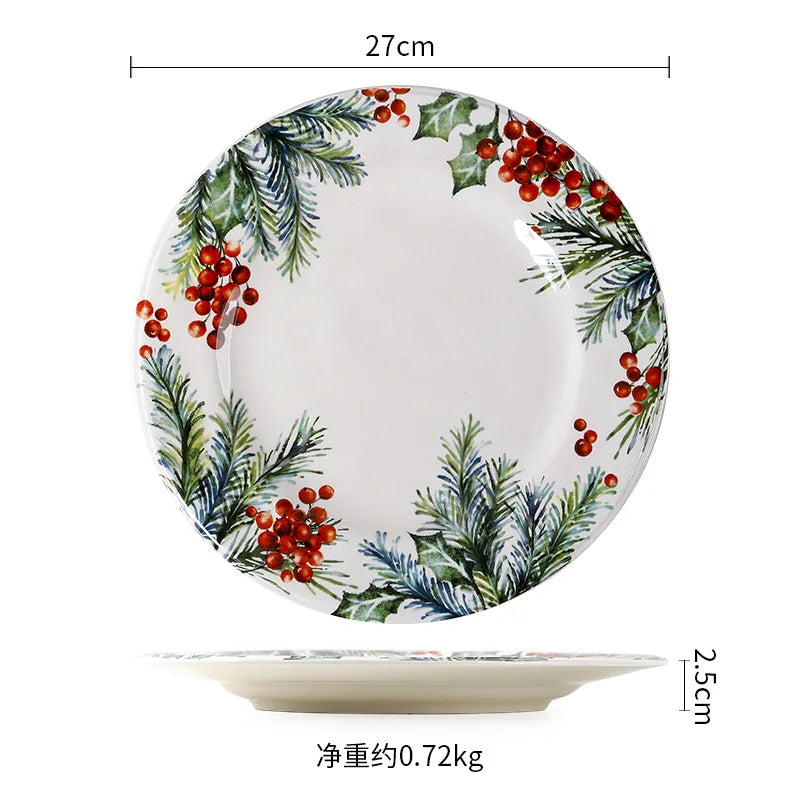 A ceramic plate with a diameter of 27cm and a height of 2.5cm, decorated with holly and pine designs in red and green. Weight is approximately 0.72 kg.