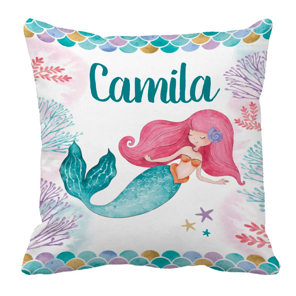 Pillow with a whimsical mermaid design, featuring a red-haired mermaid with a green tail, surrounded by colorful coral and starfish. The name "Camila" is prominently displayed above.