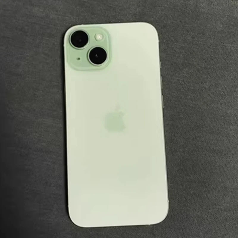 A light green smartphone with dual rear cameras and an Apple logo on the back, placed on a dark fabric surface.