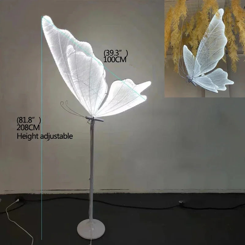 Floor lamp with a butterfly-shaped light, height adjustable to 208 cm. The luminous wings measure 100 cm. Inset shows a close-up of the butterfly detail.